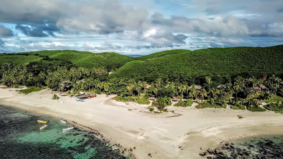 Fiji beach with boats, palms, and green hills